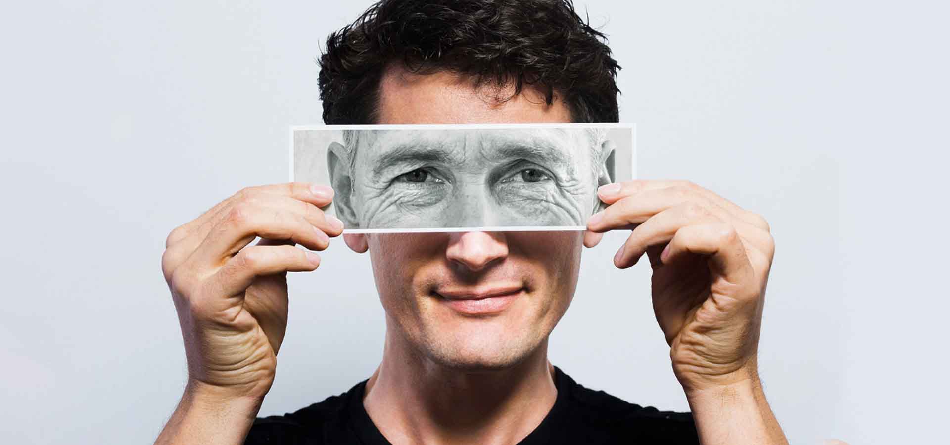 josen sosteniendo una fotografía de una mirada de persona mayor sobre su mirada.