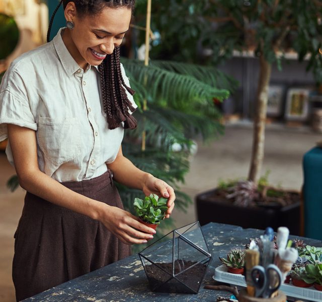 Mujer dedicando tiempo al cuidado de sus plantas en su hogar.